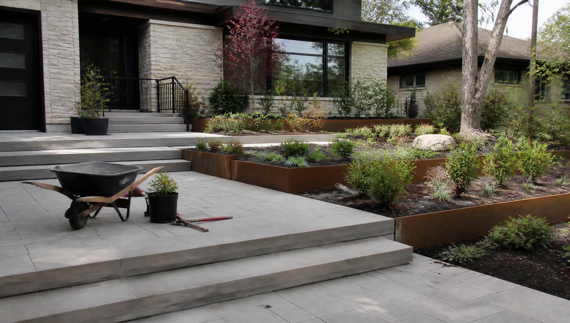 Front yard construction staging with finished paving corten steel planters and newly planted shrubs. Images Created by www.future-home.shop